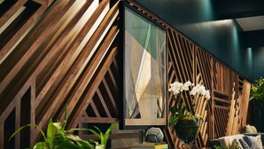 A modern interior with a geometric wooden wall, a framed artwork, a potted plant, and a stack of books. - Kinley Chattanooga Southside, a Tribute Portfolio Hotel (Chattanooga)