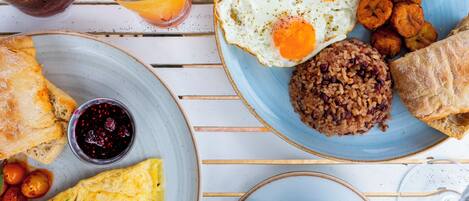 Un petit-déjeuner composé d’œufs, de pain grillé et d’une tasse de café, le tout disposé sur une table en bois blanche.