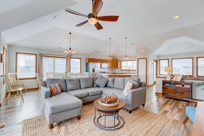 Relax in this spacious living area with a large L-shaped sofa, coffee table, and ceiling fan.