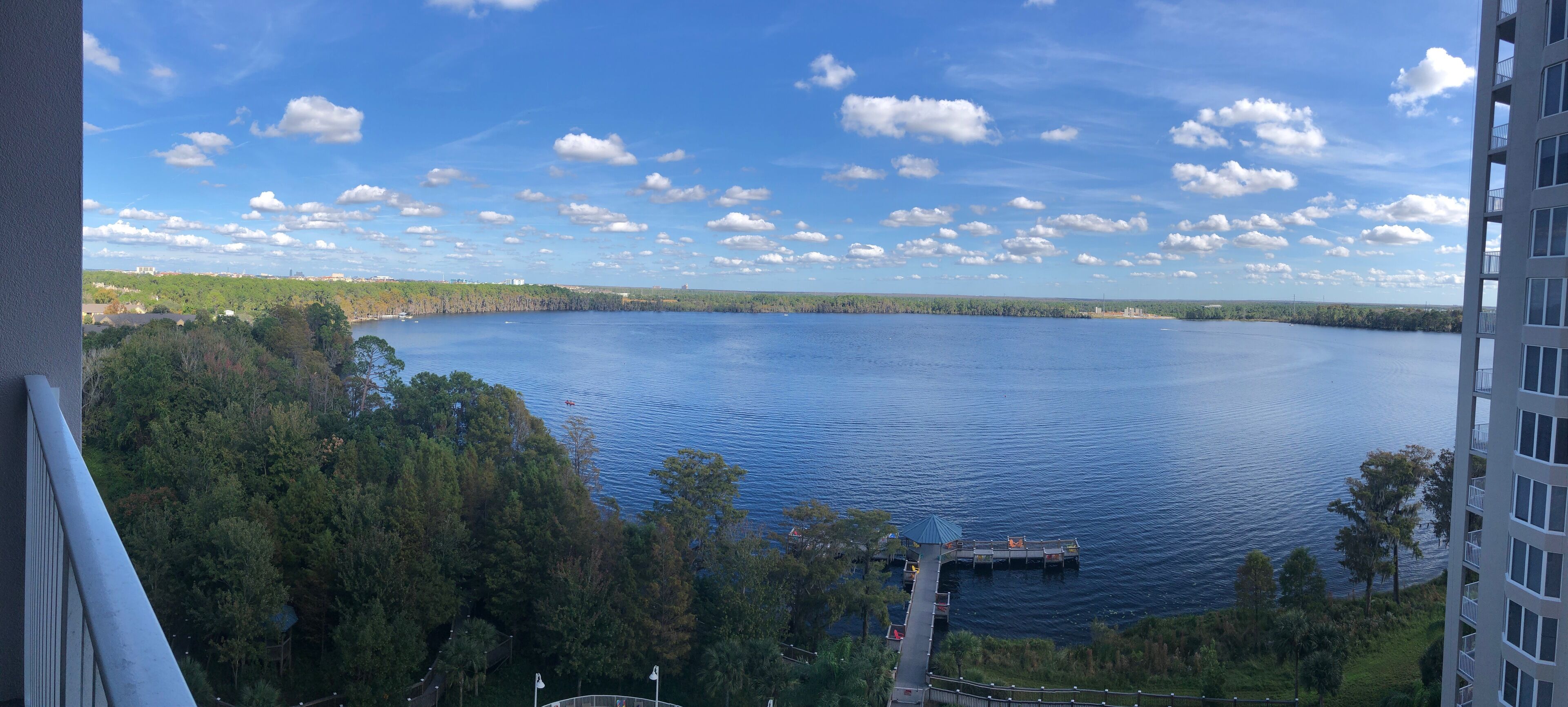A view of a lake with a dock and a building in the foreground.