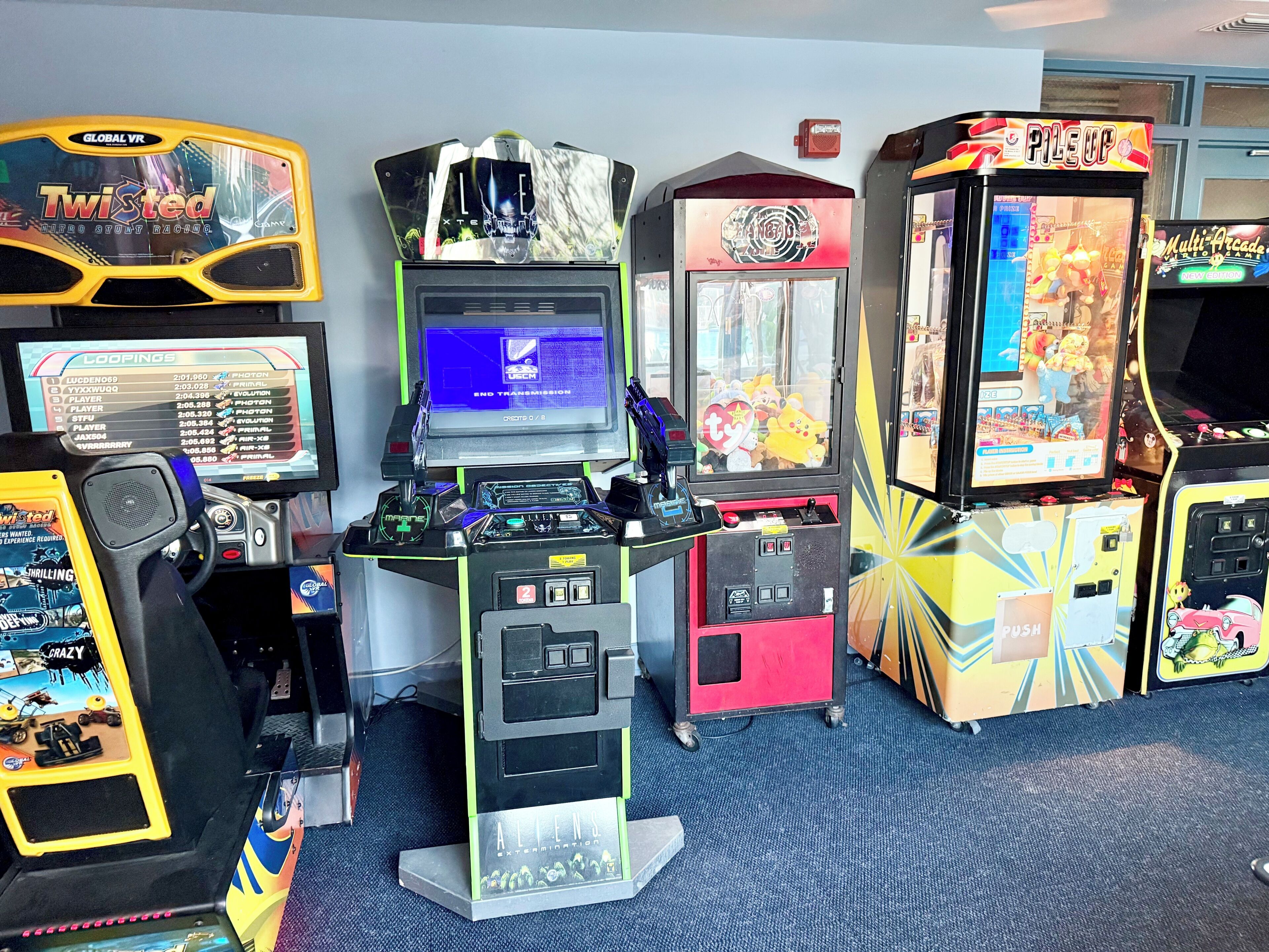 Una hilera de máquinas de arcade, incluyendo juegos como 'Twisted' y 'Global VR'.