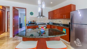 A modern kitchen with a central island, stainless steel appliances, and wooden cabinets.