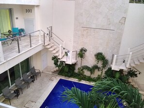 A multi-level indoor space with a pool, stairs, and seating areas.