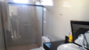 Une salle de bain avec des toilettes, un lavabo et un miroir.