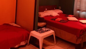 A room with two beds, a small white stool, and an air conditioning unit. - Weekly Rental Beach Sunny , Party Town Costa Rica (Coco Beach)