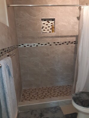 Een douche, handdoeken, zeep, shampoo