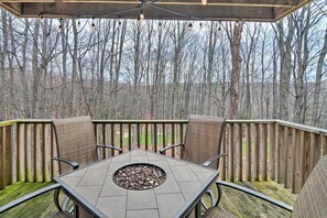 Enjoy al fresco dining and social gatherings on this outdoor deck surrounded by a lush forest.