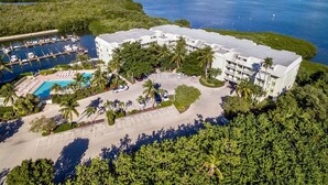 An aerial view of a hotel with a pool, parking area, and a marina. - Bayside Villas (Captiva)