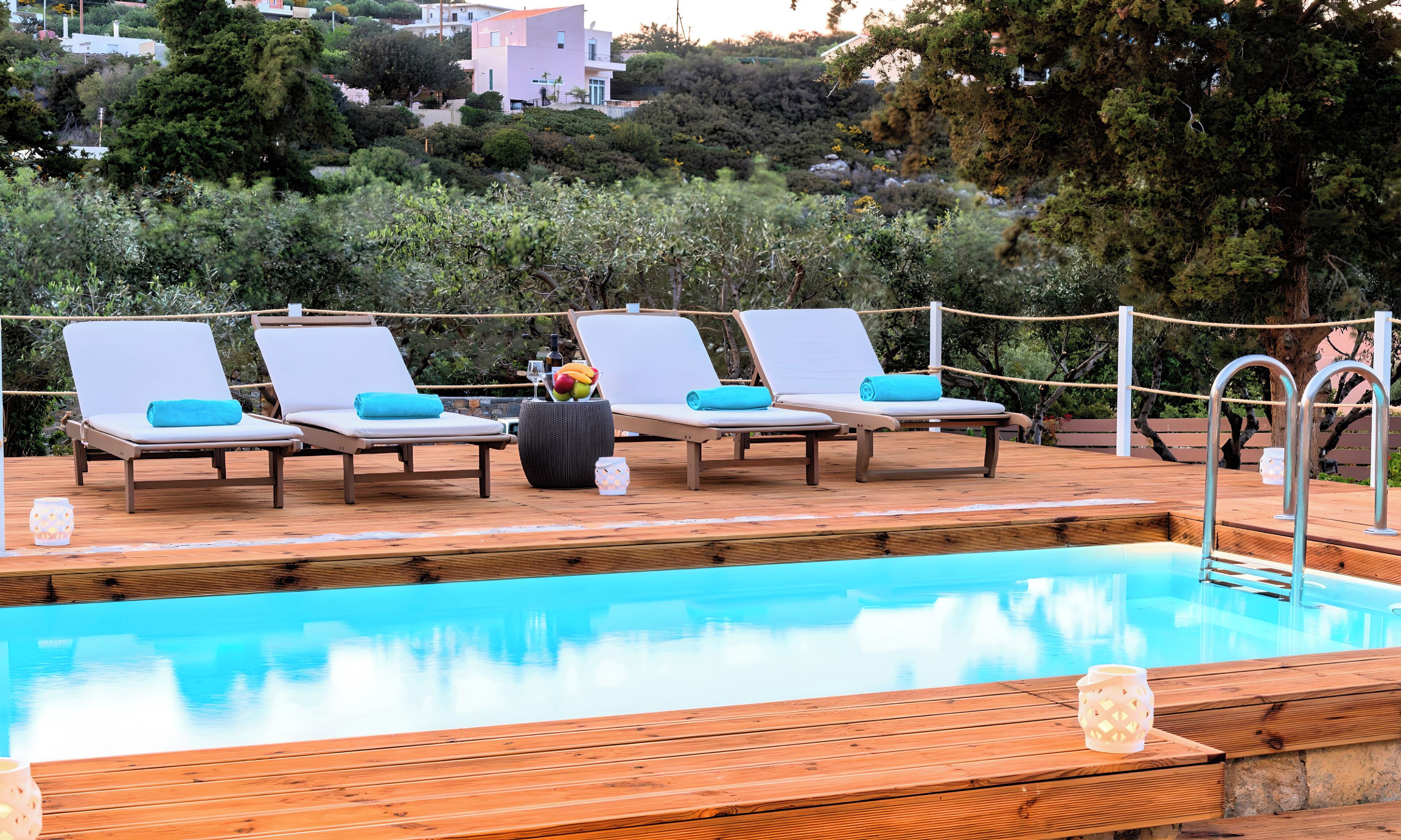 A poolside area with lounge chairs and a wooden deck.