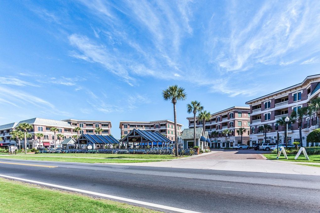 A hotel with multiple buildings, a parking lot, and a clear blue sky.