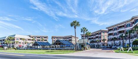 A hotel with multiple buildings, a parking lot, and a clear blue sky.