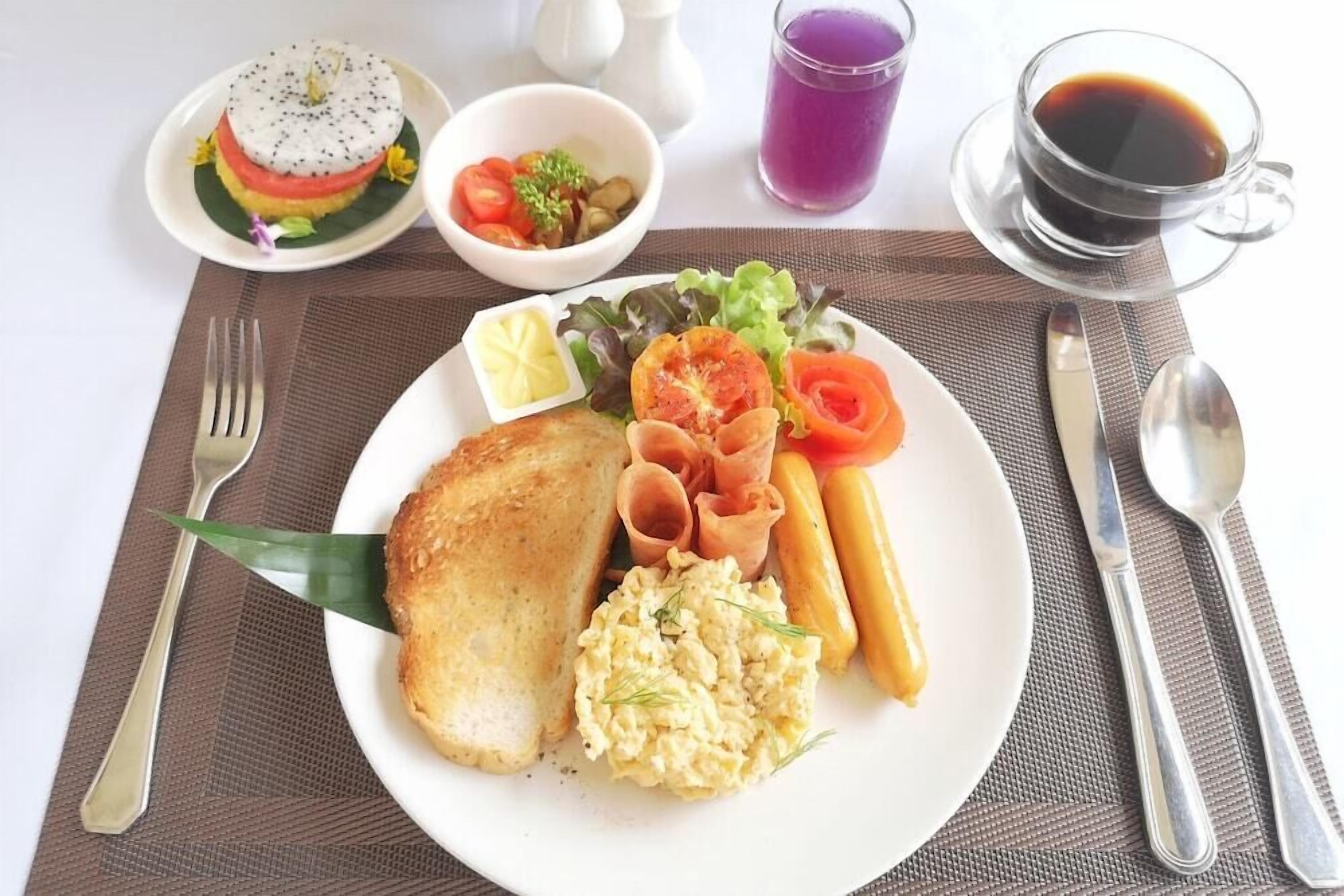 A breakfast plate with toast, scrambled eggs, tomatoes, ham, and a side salad.