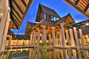 A modern building with a reflective pool and traditional architectural elements. - Suuko Wellness and Spa Resort (Chalong)