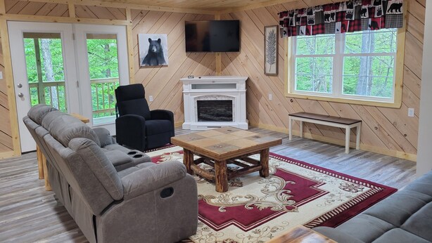 Una sala de estar acogedora con chimenea, un sofá, un sillón reclinable y un televisor.