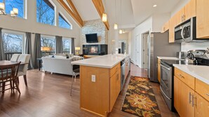 A modern kitchen with wooden cabinets, stainless steel appliances, and a large island. - Magalloway Loop Home 27 - Large family home at Saddleback (Rangeley)