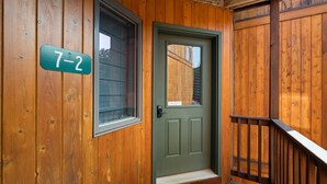 Una puerta de madera con marco verde y una placa que indica la habitación 7-2.