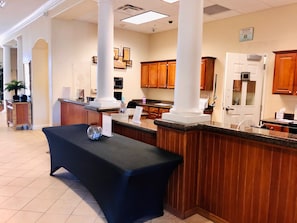 A reception area with a reception desk, a potted plant, and a sign indicating recycling. - Renovated Lakefront Condo · Disney 1 Mile · Fireworks Views · 2 Full Baths (Orlando)