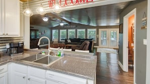 A modern kitchen with granite countertops, a built-in sink, and a coffee maker. - Ferriday Lakehouse w/ Private Dock, Deck, & Yard! (Ferriday)
