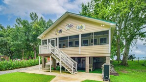 A two-story building with a balcony and a staircase. - Ferriday Lakehouse w/ Private Dock, Deck, & Yard! (Ferriday)