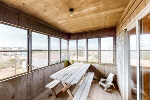 Relax in a serene outdoor space with a bench and picnic table, surrounded by large windows offering a view of the surrounding landscape.