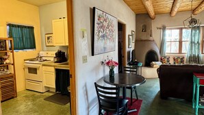 Un interior acogedor con techo de madera, una zona de comedor con mesa y sillas, un sofá y una chimenea.
