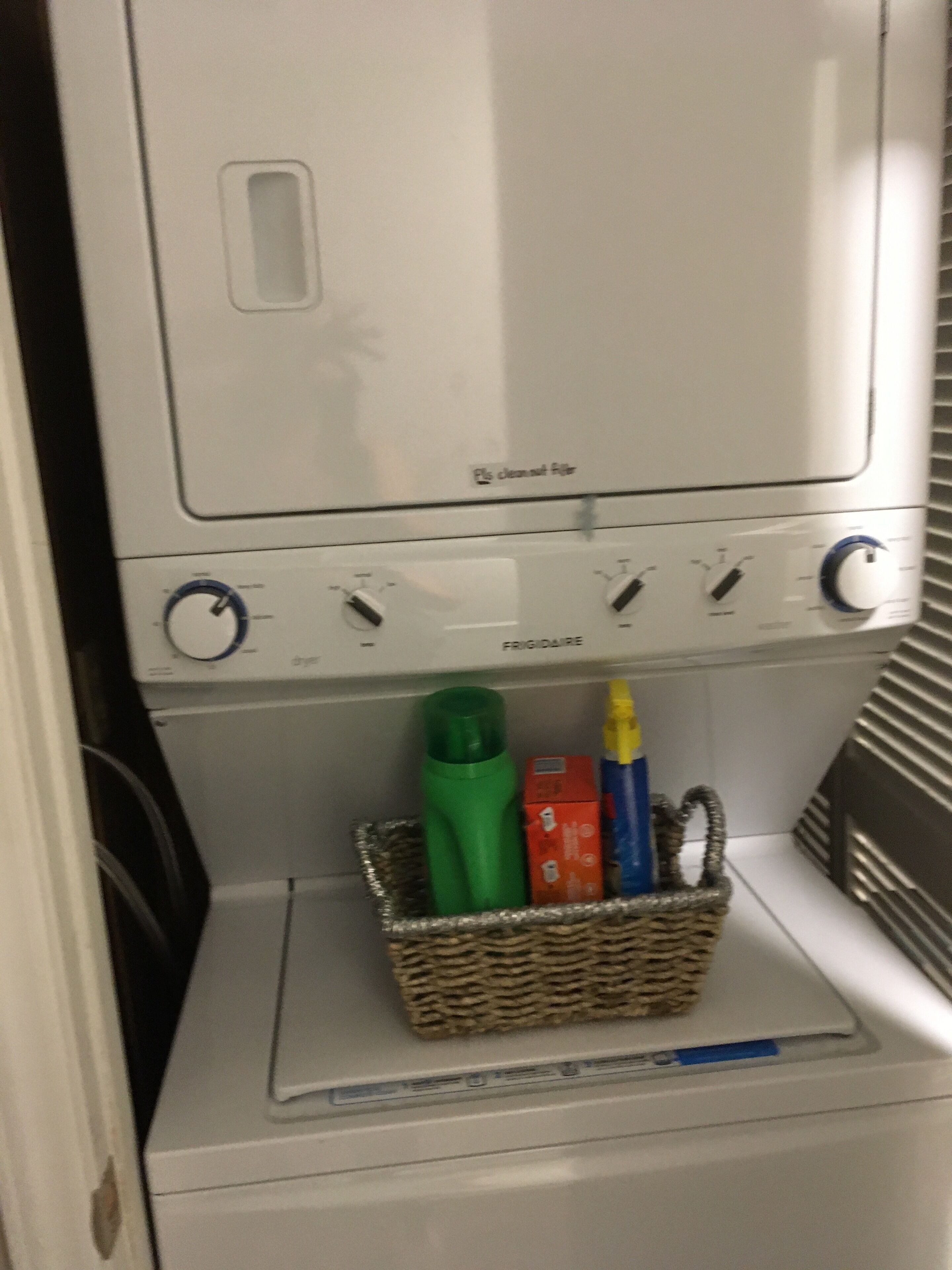 Eine Waschmaschine mit Frontöffnung und einem Korb voller Reinigungsmittel.