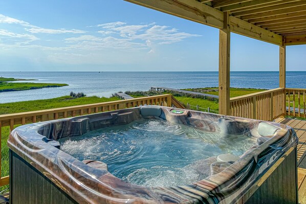 Relax on the deck with a panoramic view of the water and enjoy a soak in the hot tub.