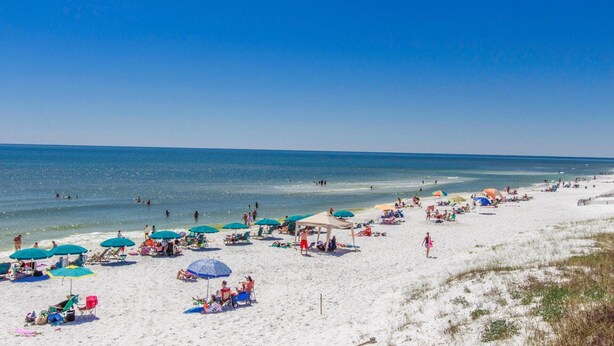 A beach with white sand, clear blue water, and umbrellas. - Margarita Sunrise – Charming Florida Cottage Near 30A Beaches (Santa Rosa Beach)