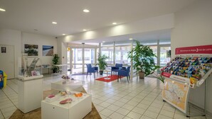 A spacious lobby with a reception desk, seating area, and informational displays.