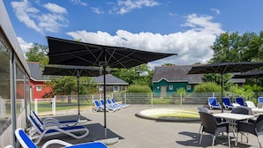 A poolside area with blue lounge chairs, umbrellas, and a table with chairs. - Cosy apartment in villa for 6 people with pool, internet, TV, terrace and pets allowed (Marson)