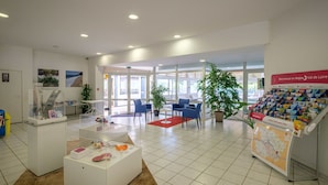 A spacious lobby with a reception desk, seating area, and informational displays. - Cosy apartment in villa for 6 people with pool, internet, TV, terrace and pets allowed (Marson)