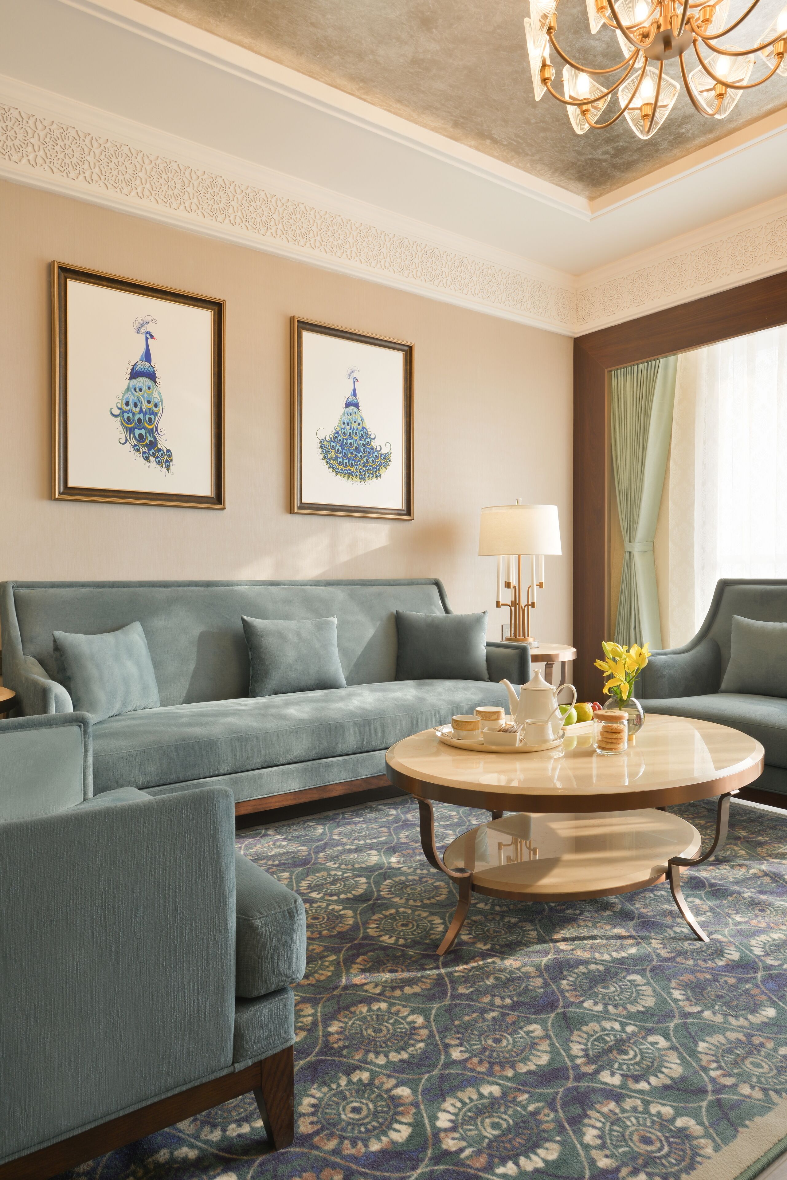 A room with a sofa, armchairs, a coffee table, and framed artwork on the wall.