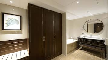 A modern bathroom with a large dark wooden wardrobe, a marble floor, a round mirror, and a sink with a vanity.