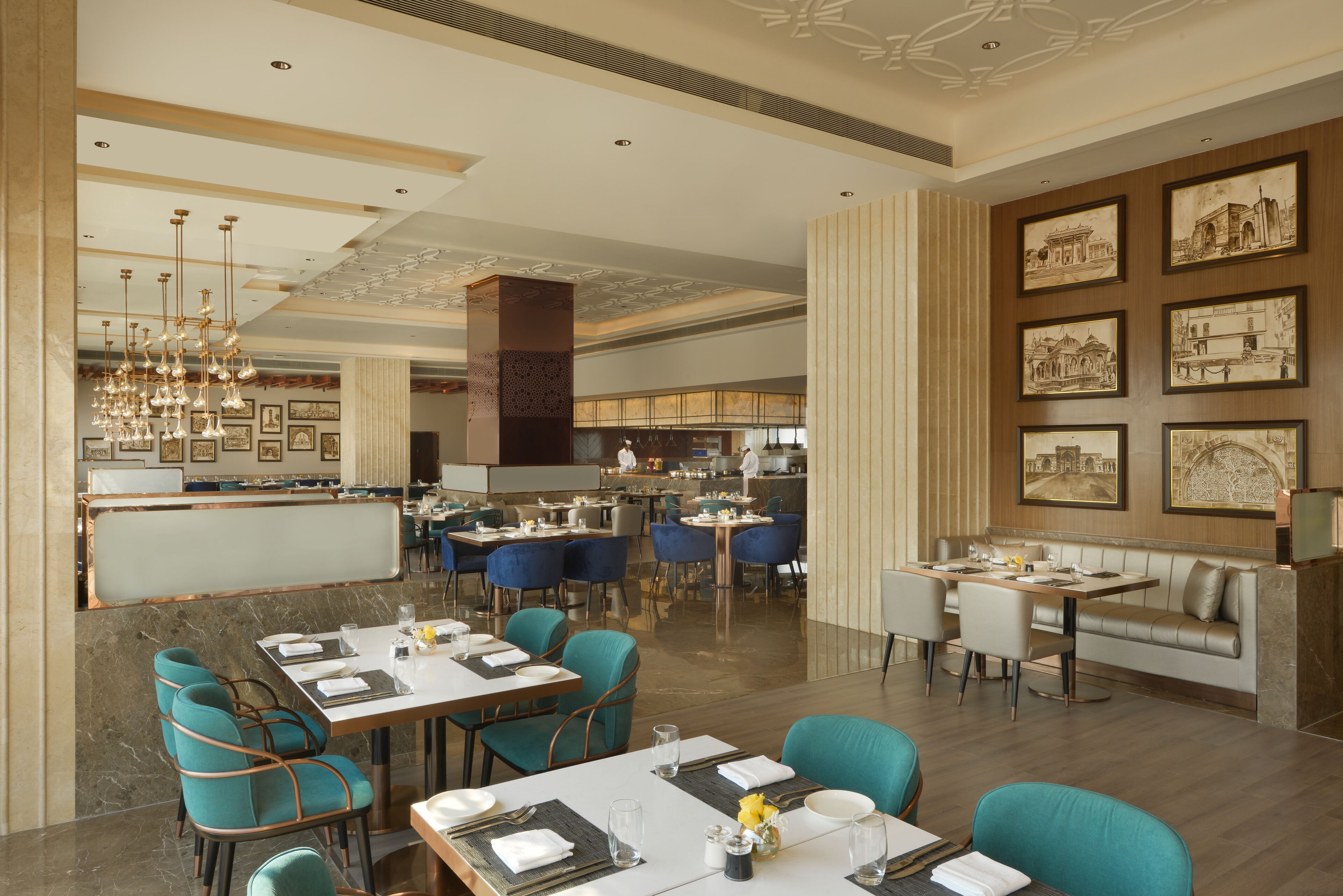 Un restaurante espacioso con techos altos, iluminación moderna y diversas opciones de asientos, incluyendo mesas y cabinas.