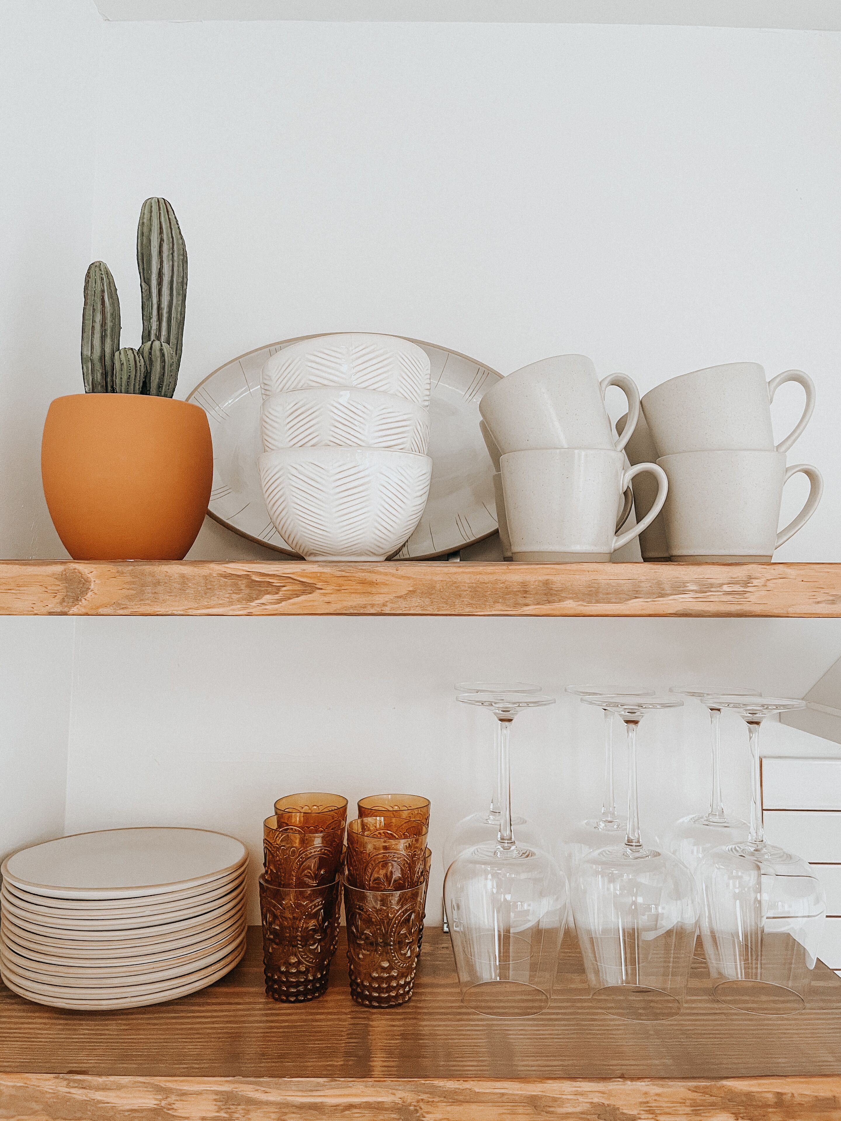 Un estante con diversos utensilios de cocina, como platos, tazones y tazas.