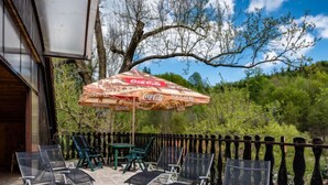 Un área de estar al aire libre con sillas y un paraguas con la marca Coca-Cola.