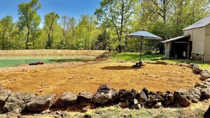 A backyard with a swimming pool, a patio area, and a house. - Bertucci’s Country Cabin (Williford)