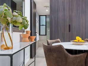 A modern kitchen with a marble countertop, a potted plant, and a bowl of lemons.