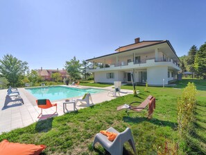 Enjoy a relaxing stay in this home with a spacious backyard featuring a swimming pool and comfortable lounge seating.