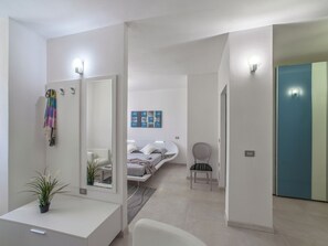 A modern bedroom with a bed, bedside table, chair, and a large mirror. - Plush Villa Apartment in Tavullia with Hot Tub (Tavullia)