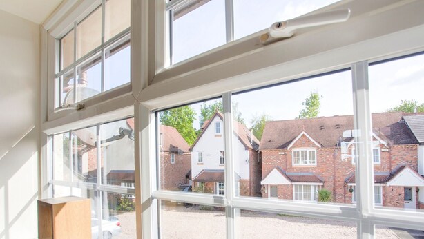 A room with large windows overlooking a courtyard with brick houses. - Rustic Holiday Home in Birmingham near Motorcycle Museum (Birmingham)