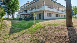 A two-story building with a balcony, outdoor seating, and a small garden area. - Sunny Stay in Tavullia Hills (Tavullia)
