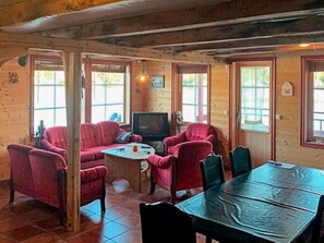 A wooden cabin interior with a sofa set, a television, and a dining table. - 6 Person Holiday Home in Hosteland (Masfjorden)