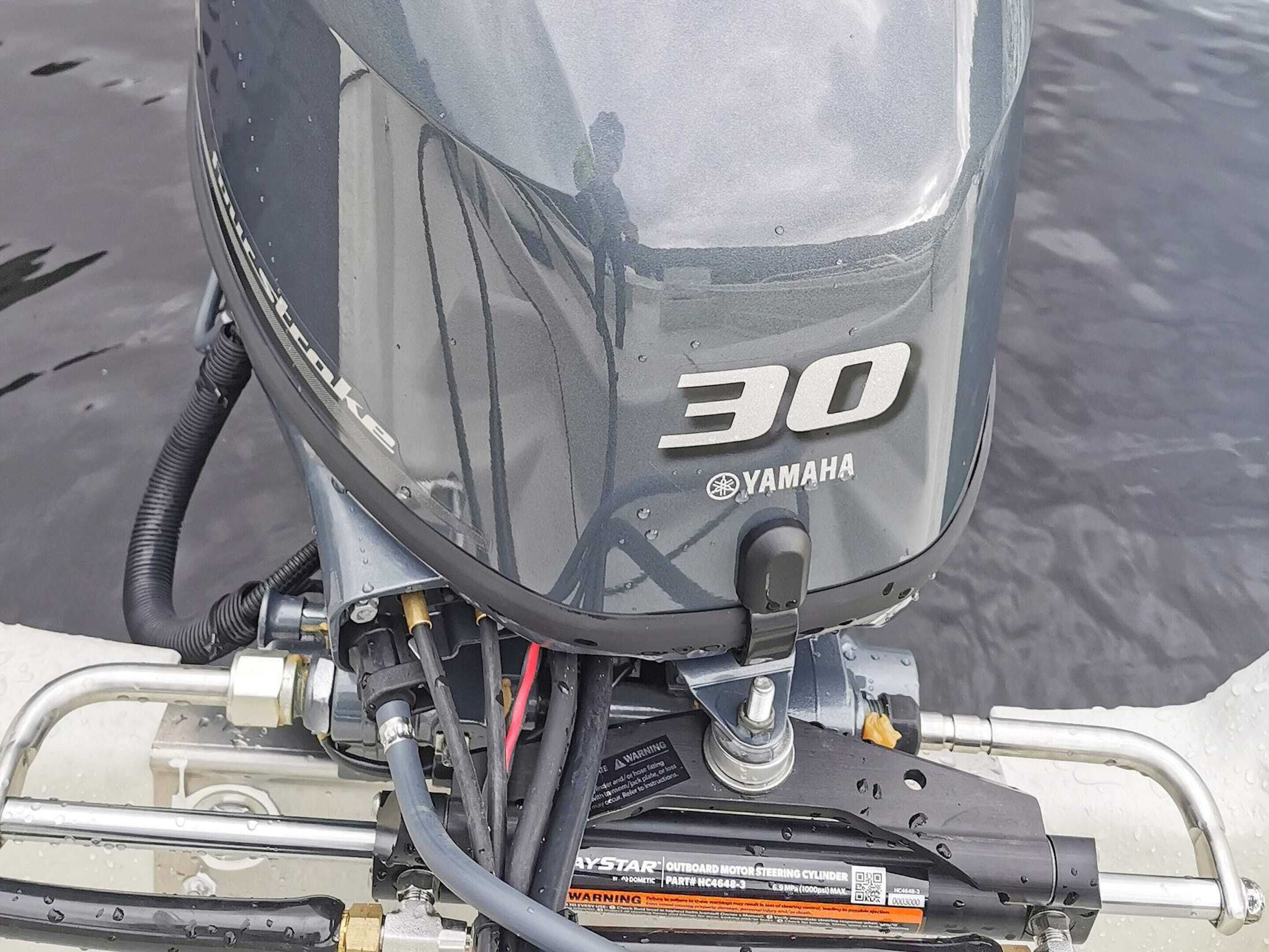 Un moteur hors-bord Yamaha avec une étiquette indiquant une puissance de 30 chevaux, numéro de pièce HC4648-3, et une étiquette d’avertissement.