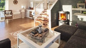 A spacious living room with a fireplace, a staircase, and a cozy seating area. - 6 Person Holiday Home in Hartbakke (Solund)