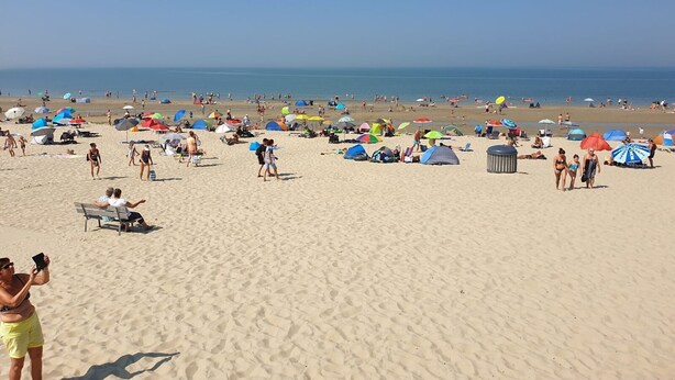 A sandy beach with tents and umbrellas, people walking, and a clear blue sky. - Unique Home at Bottom of Dunes near Center of Zoutelande (Zoutelande)
