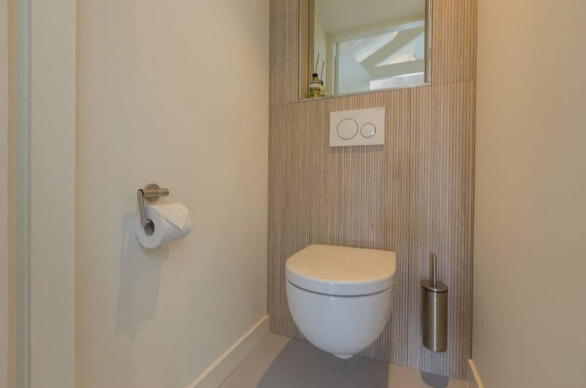 Un bagno moderno con un water, un portasciugamani e un bidet.
