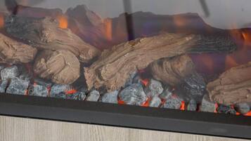 A fireplace with logs and glowing embers.