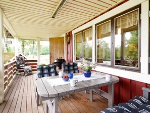 A covered patio with a wooden table and chairs, a barbecue grill, and a view of the outdoors. - 6 Person Holiday Home in Torsby (Torsby)