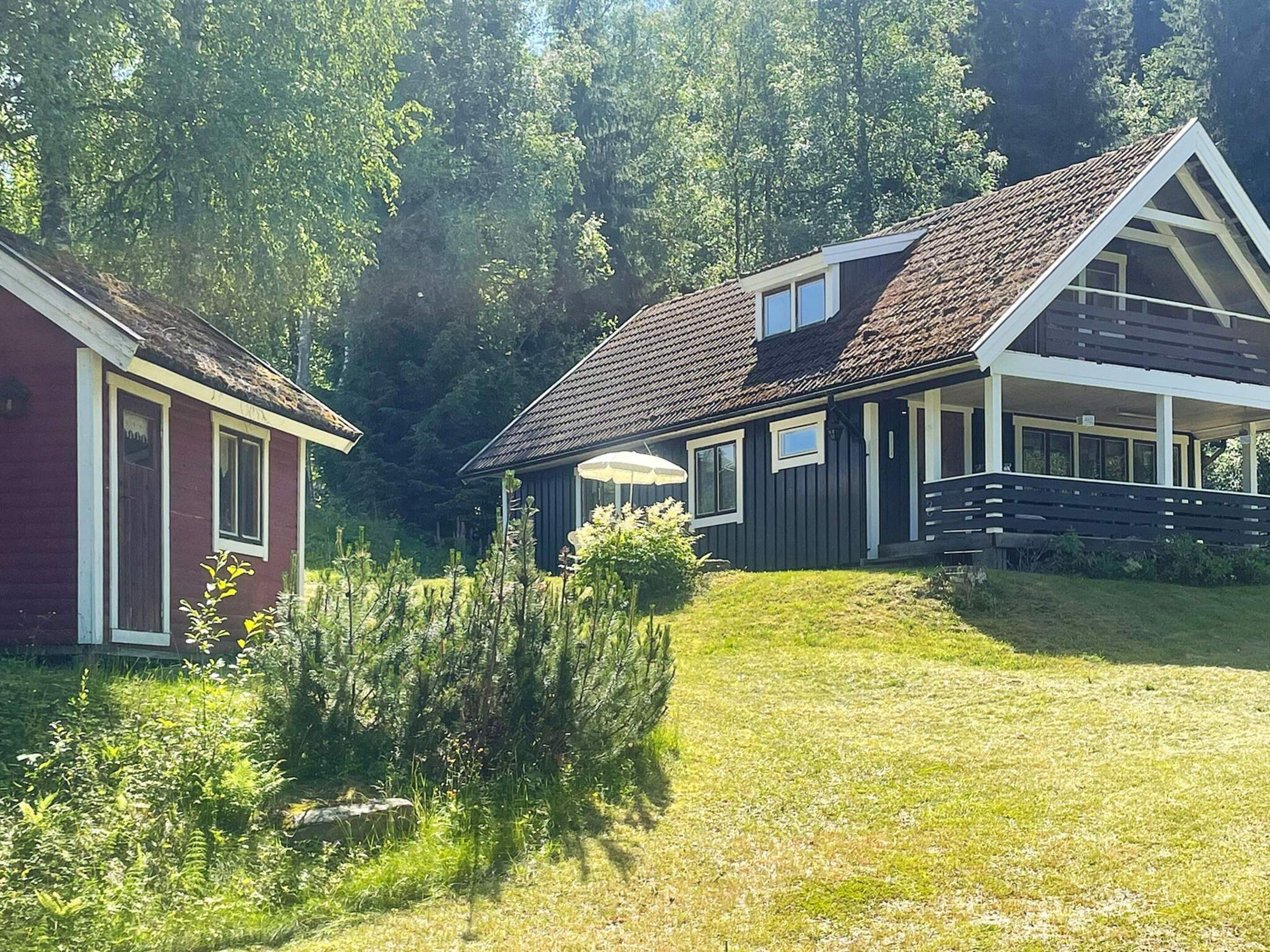 A two-story house with a sloped roof, a covered porch, and a small garden area.